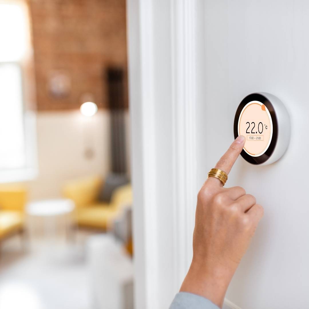 Woman adjusting smart thermostat