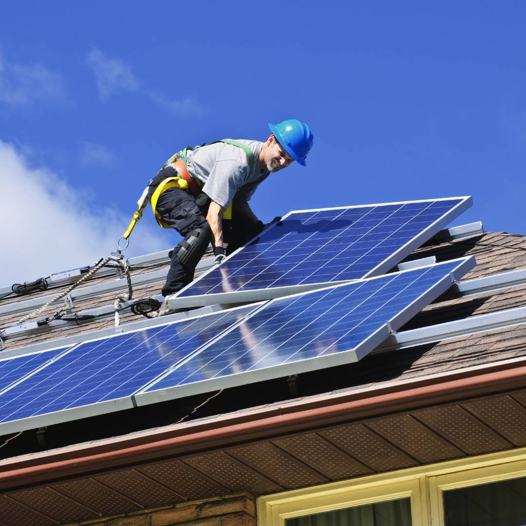 A solar installation technician installing solar panels