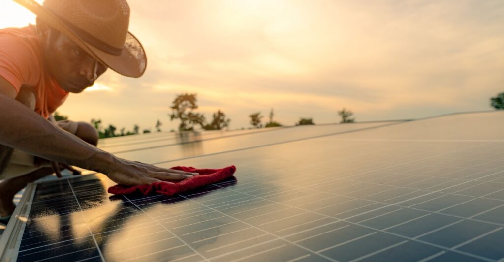 man dusting solar panel