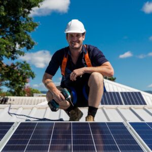 Solar panel installer smiling for a photo while he works
