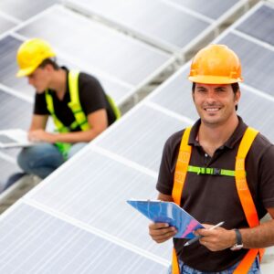 workers in safety gear with clipboards inspecting solar panels