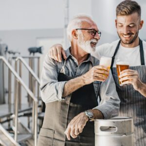 two brewers cheering a beer in a brewery