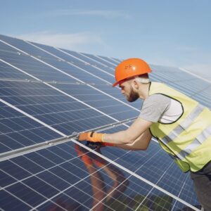 a man in safety gear working on a solar panel