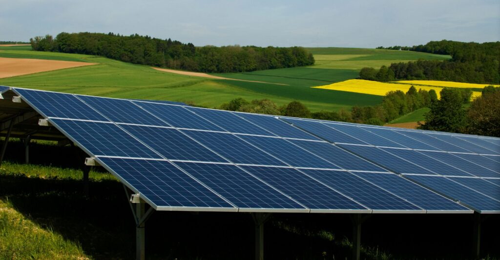 solar panels in a large green field with hills