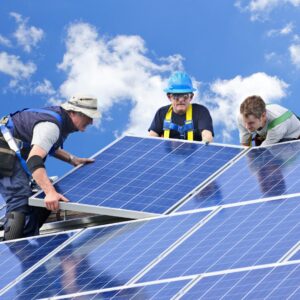 workers in safety gear installing solar panels
