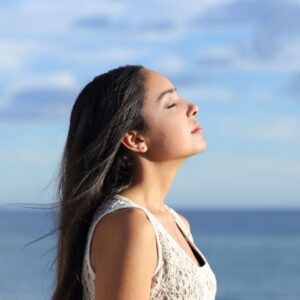 a person taking a calming breath outside on a sunny day