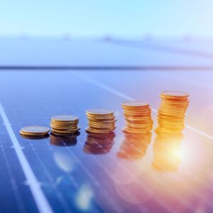 stacks of increasing coins on a solar panel with a sun shining on it