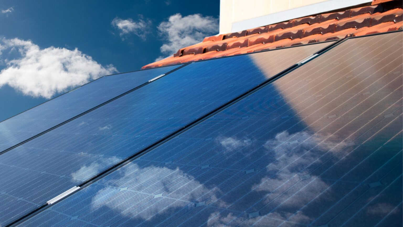 solar panels reflecting the sky and clouds