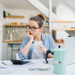 Person looking at their bills spread out on a table